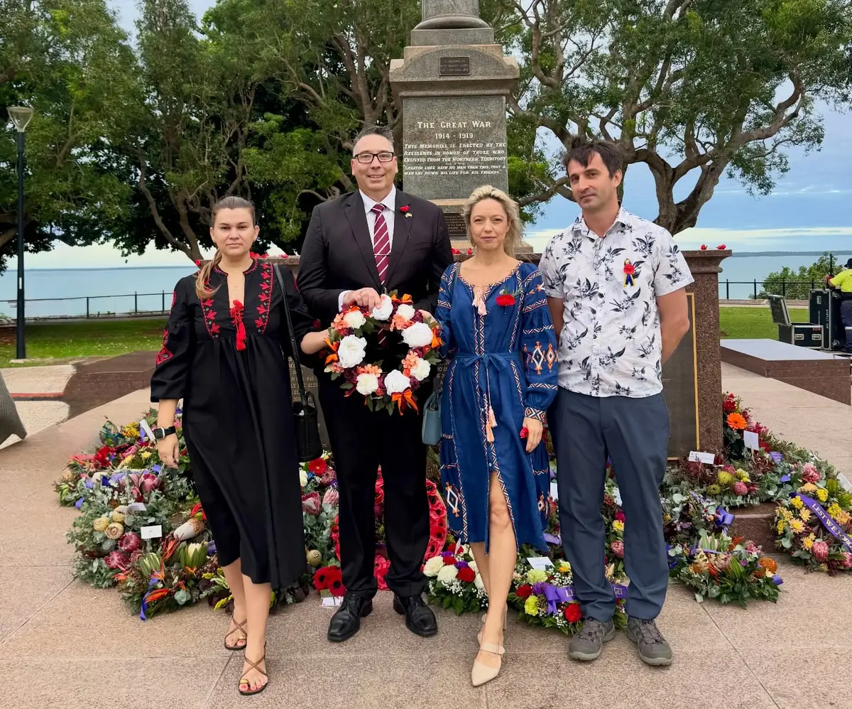 Latvian and Ukrainian representatives holding their shared wreath at the Darwin Cenotaph