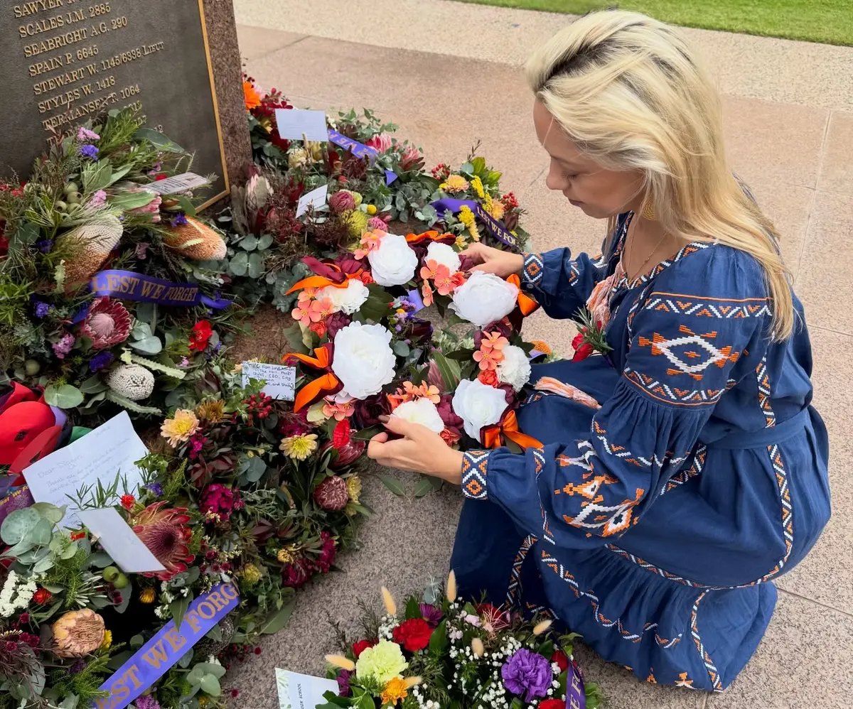 Latvian representative placing the shared wreath among the tributes
