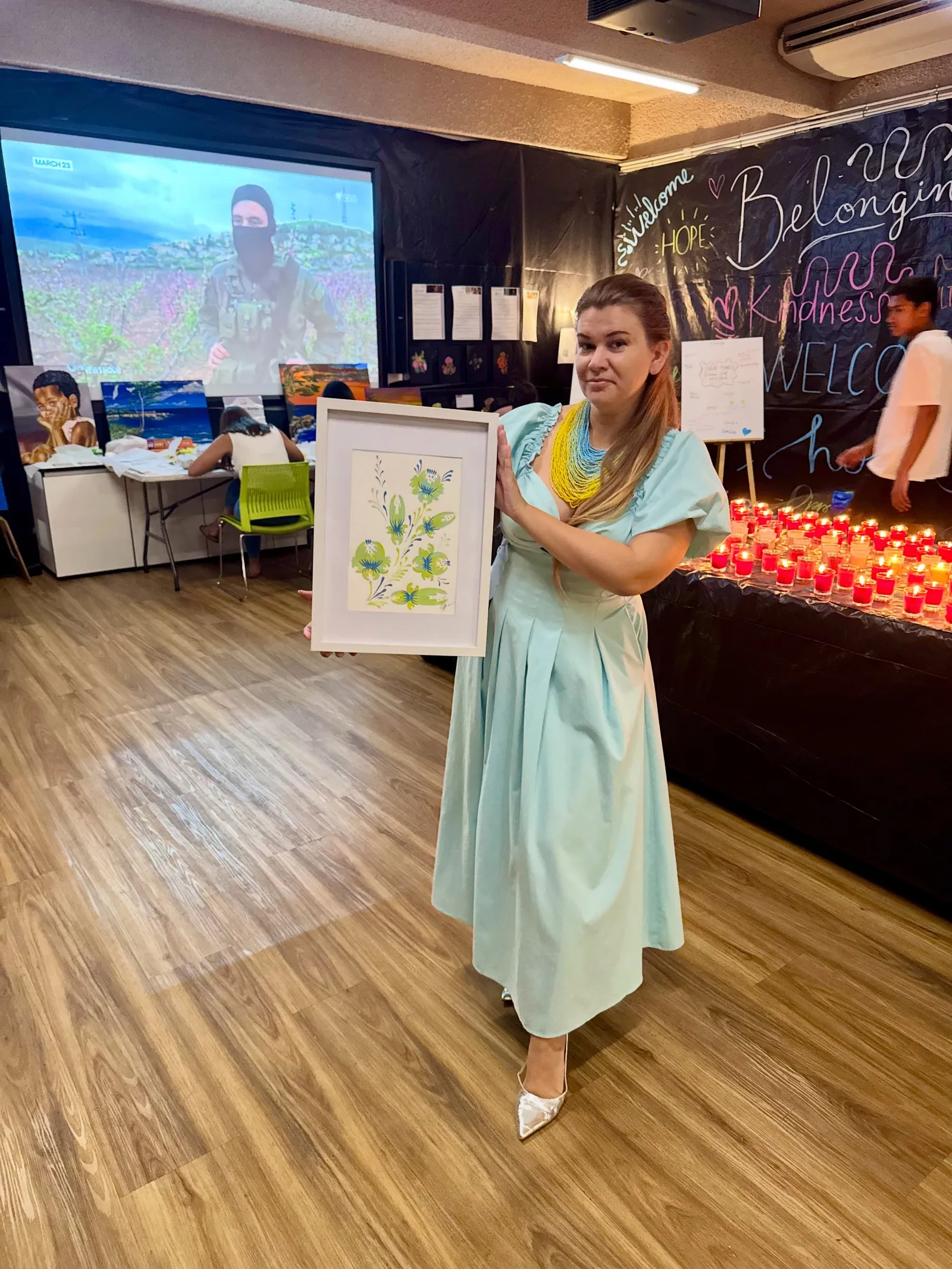 Ukrainian community representative presenting a floral artwork at Inside the Frame