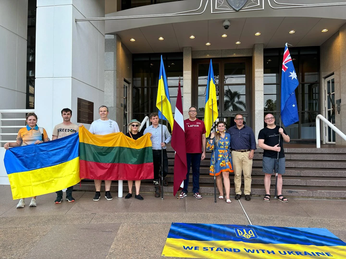 Community members with Ukrainian, Latvian, Lithuanian, and Australian flags at Parliament House in Darwin